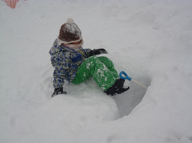 雪に穴を掘って遊ぶ息子