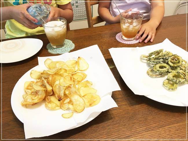 ポテトチップスとゴーヤチップスを食べる子供たち