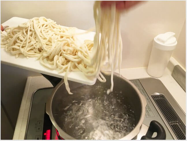 たっぷりのお湯にうどんの麺を入れて茹でる