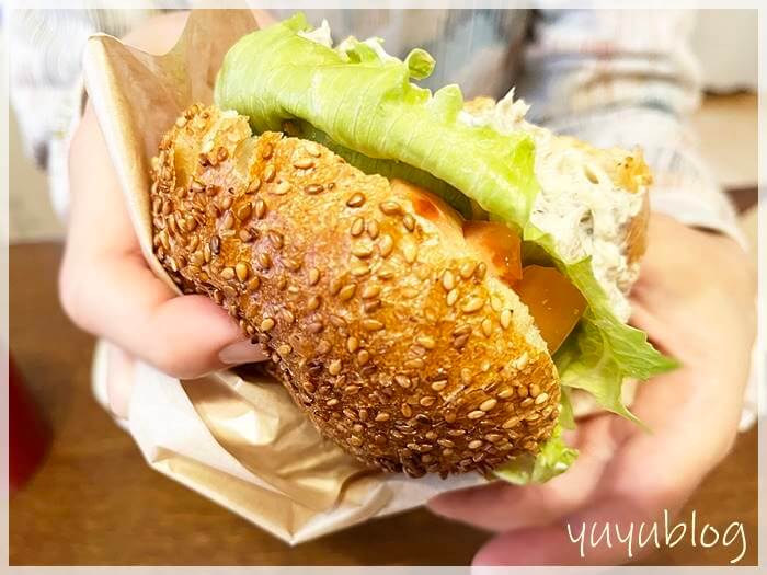 「パンで」のハンバーガーを手に持ったところ