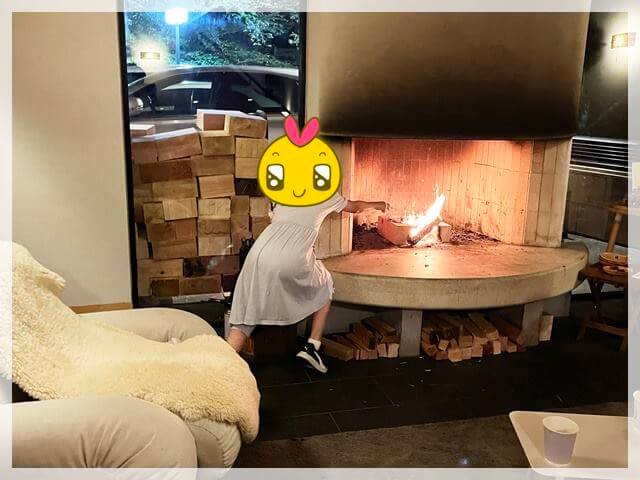 アンドホテルのロビーにある暖炉で焼マシュマロを作る娘