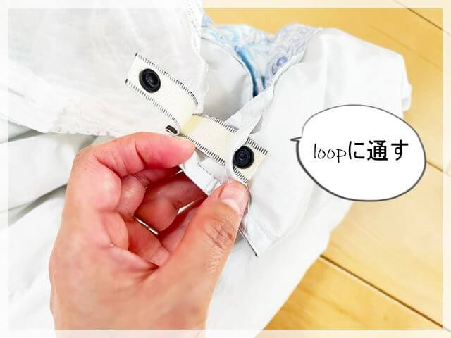 布団カバーにセリアのネームリボンを取りつけ、布団のループにとおす