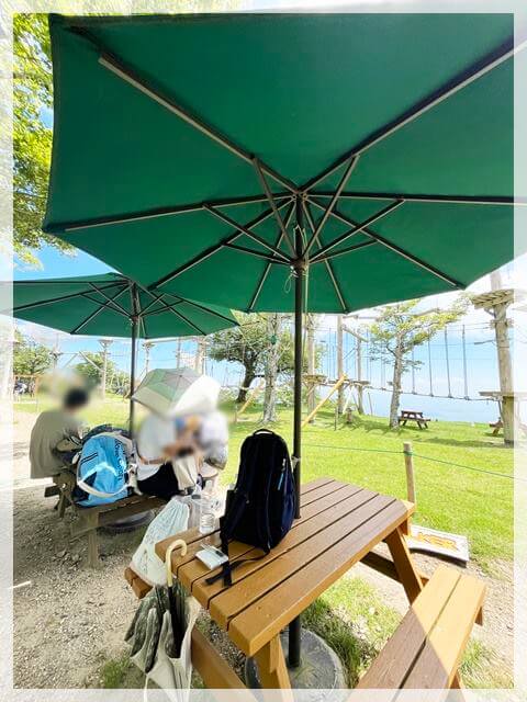 琵琶湖バレイのアスレチック場にあるパラソルつきのテーブル席