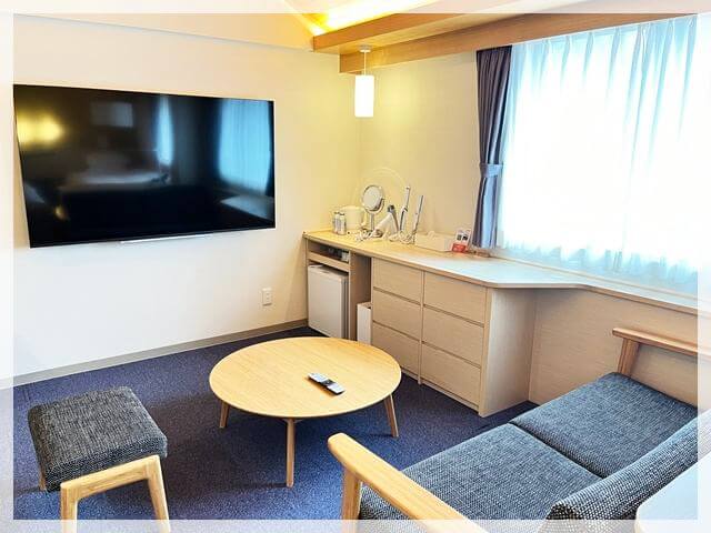 倉敷アイビースクエア「デラックススーペリアツイン」の部屋の様子（ソファやチェスト、リファのヘアアイロン、テレビ等）③